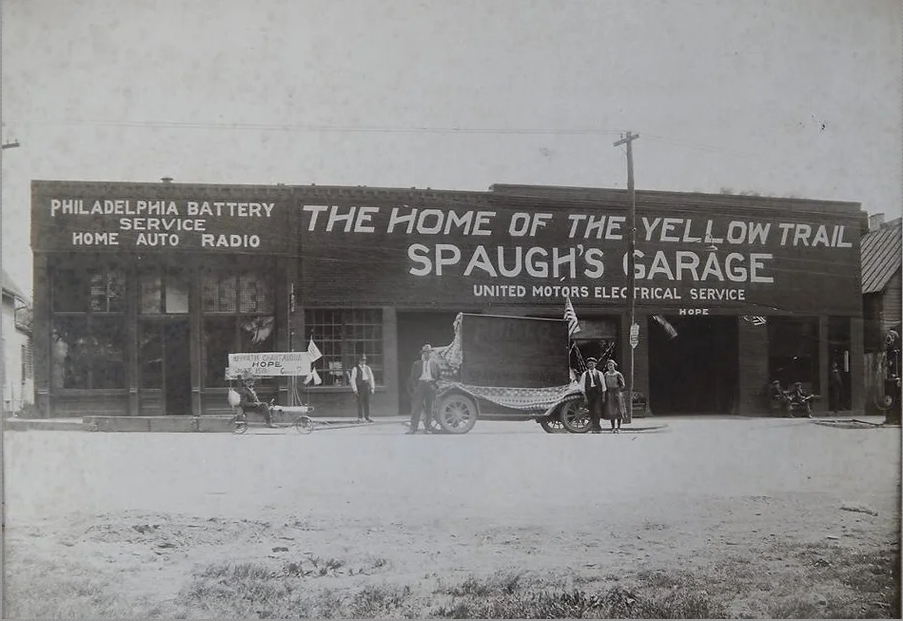 Several people in front of an automobile shop, "Spaugh's Garage"